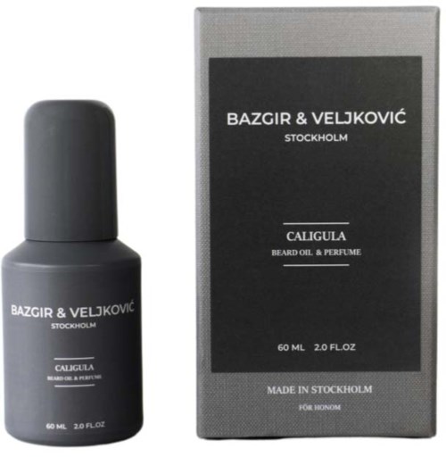 A small dark bottle of beard oil and perfume next to a box with similar branding and details.