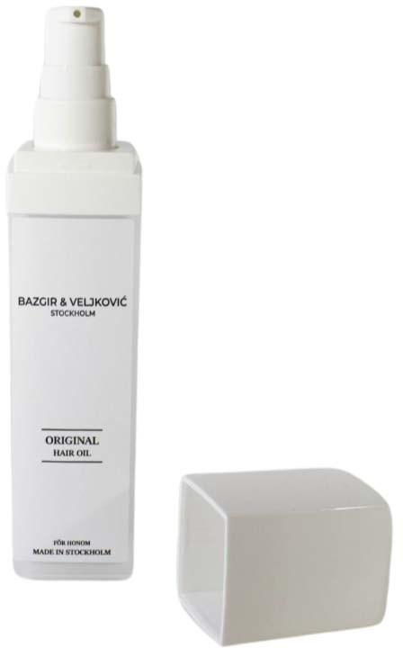 A white hair oil bottle with a spray top, and a separate white cap.