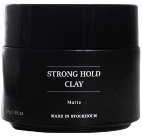 A black container of clay product labeled 'Strong Hold Clay Matt, made in Stockholm.'