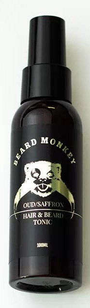 Schwarze Flasche mit Bart- und Haartonikum, Logo eines Affen und weißer Text. Konzentriere dich auf das Etikett deines Produkts.