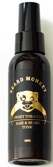 A black spray bottle with gold and white text and a beard monkey logo for beard and hair tonic.