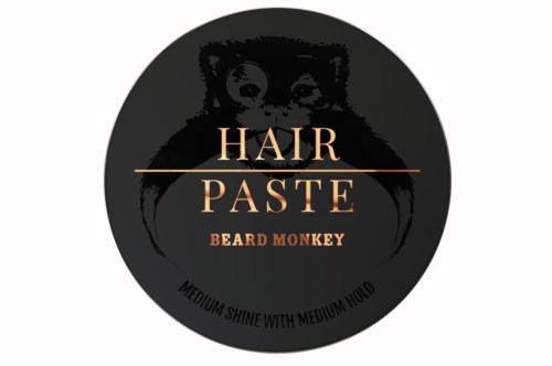 En rund logo med et bjørneansikt, tekst for hårpasta og skjeggmonkey, og en merknad om glans og hold.