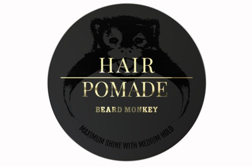 En svart sirkel logo med et apeansikt, tekst om hårpomade og bruksanvisning.