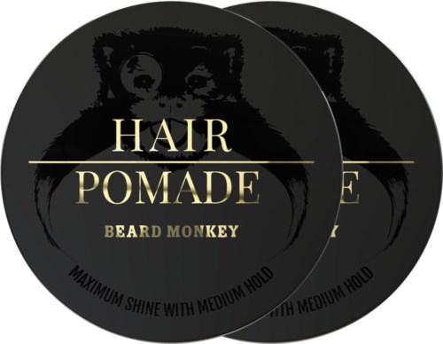 En svart sirkelformet etikett med en ape, med gulltekst som sier "Hair Pomade," "Beard Monkey," og "Maximum shine with medium hold."