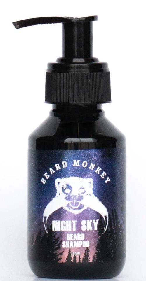 Eine schwarze Flasche mit Pumpkopf, Beschriftung 'Night Sky,' 'Beard Shampoo' und 'Beard Monkey' mit Nachthimmel und Waldmotiv.