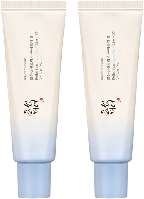 Two white tubes with blue caps, labeled with Asian characters, stand side by side, possibly skin or sun protection products.