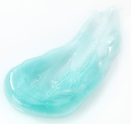 Eine blau-grüne Gel mit glatter, glänzender Oberfläche und einigen Blasen im Inneren.