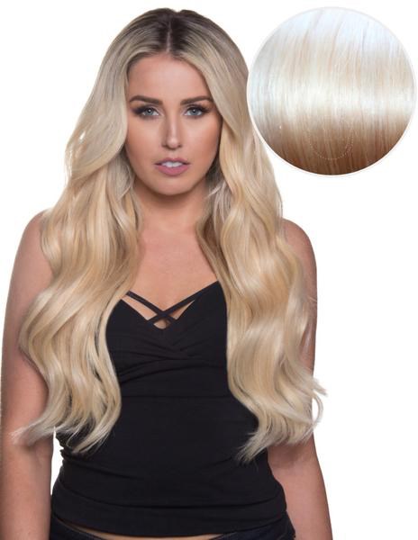 Eine Frau mit langen, gewellten, blonden Haaren trägt ein schwarzes Oberteil. Ein Kreis zeigt Haarfarbinformationen.