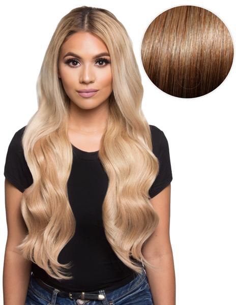 Eine Frau mit langen, gewellten blonden Haaren, trägt ein schwarzes T-Shirt, Nahaufnahme ihrer Haarfarbe.