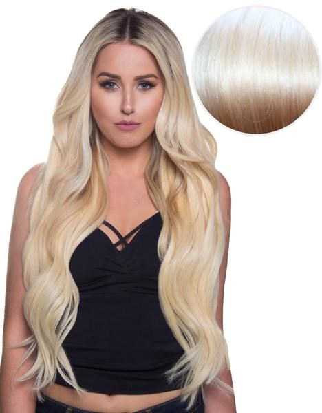 Eine Frau mit langen, lockigen blonden Haaren im schwarzen Oberteil, mit einem Kreis, der ihre Haarfarbe zeigt.