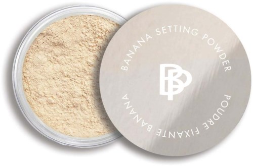 A round container of banana setting powder with a beige lid showing the product name and logo.