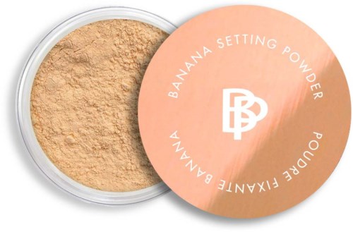 A container of banana setting powder with a pink lid that has white text and logo, showing the powder inside.