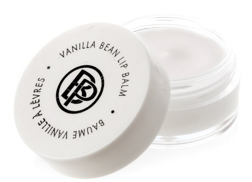 A small round container with white lip balm, labeled 'Vanilla Bean Lip Balm' and a logo on top.