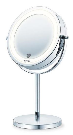 Een ronde spiegel met ingebouwde verlichting op een standaard, gebruikt voor persoonlijke verzorging of make-up.