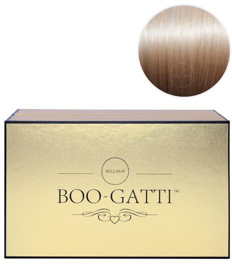 Een crèmekleurige doos met 'Boo-Gatti' logo en hartversiering, boven een ronde, beige tafel of oppervlak.