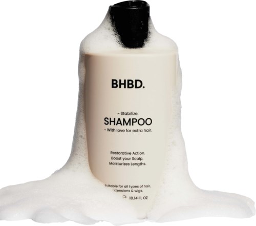 A shampoo bottle labeled "BHBD" is covered with foam and set against a white background.