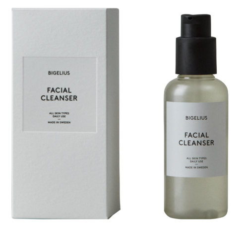 En ansiktsrengöring i en flaska med pump, bredvid förpackningskartongen. Etiketten säger "Bigelius Facial Cleanser."