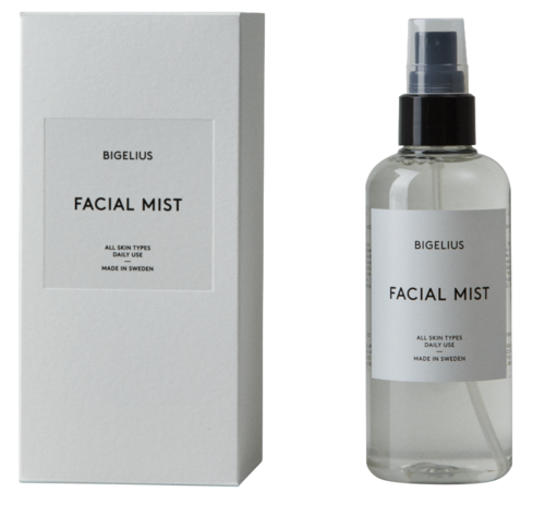 En tydlig sprayflaska märkt 'BIGELIUS FACIAL MIST' bredvid en vit box med samma etikett. Passar alla hudtyper.
