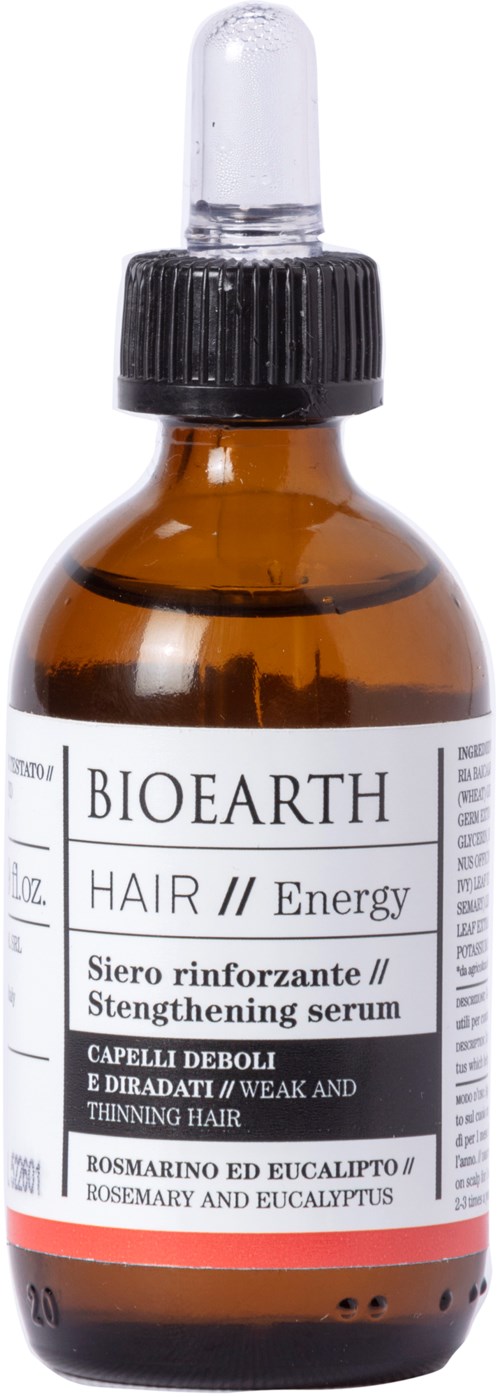 Een kleine amberkleurige fles met pipetdop, met label 'BIOEARTH HAIR Energy', bevat versterkend en dunner wordend haarserum.