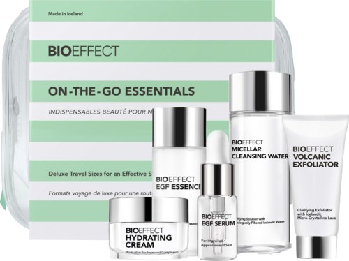 Set of four skincare products with silver caps and green and white packaging for cleansing and exfoliating skin.