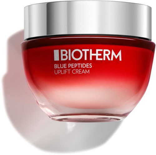 En rød krukke med sølvlokk merket 'Biotherm Blue Peptides Uplift Cream' skinner i lyset.