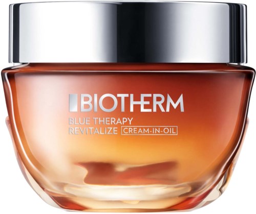 Et glass med Biotherm Blue Therapy Revitalize cream-in-oil med sølvhette og karamellfarget glass.
