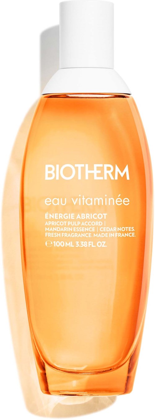 Eine Biotherm-Hautpflegeflasche mit orangefarbiger Flüssigkeit und weißem Deckel, beschriftet Eau Vitaminee mit Aprikosenenergie.