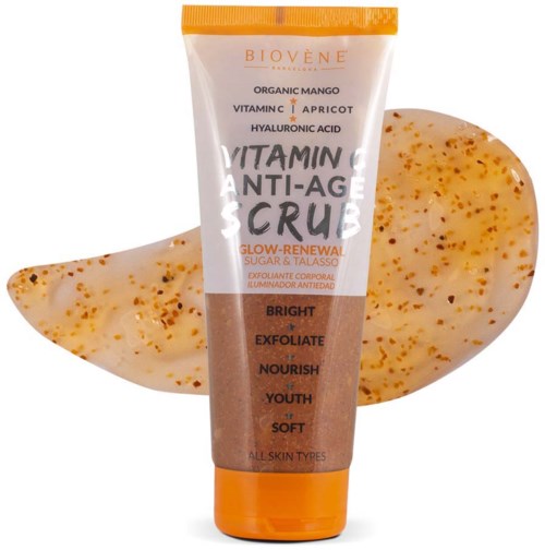 Eine Tube mit der Aufschrift 'Vitamin C Anti-Age Scrub' mit orangefarbener Kappe, zwischen zwei gewölbten, strukturierten Seifen.