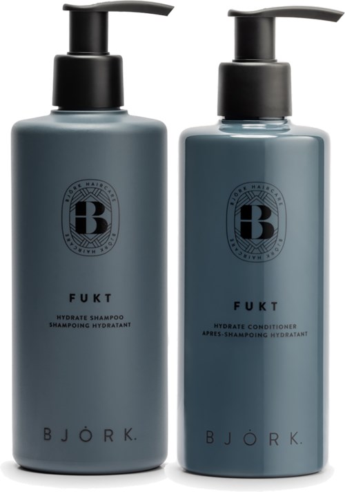 Zwei Flaschen Shampoo und Conditioner mit schwarzen Pumpen, beschriftet 'FUKT' von Björk, in grauen Behältern.