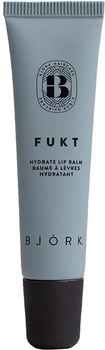 Ein weißer Tube mit schwarzem Deckel, hat Text für feuchtigkeitsspendenden Lippenbalsam, namens Fukt von Björk, und ein Logo an der Spitze.
