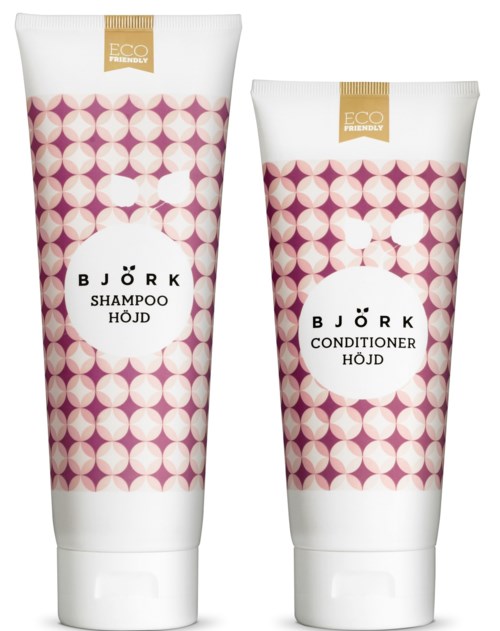 Två hårvårdsprodukter i tuber etiketterade 'Schampo' och 'Balsam' med rosa och vita geometriska mönster, märkta miljövänliga.