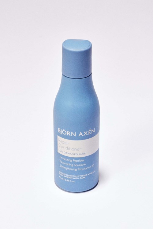 Een blauwe fles met Björn Axén conditioner voor beschadigd haar met een eenvoudig label.