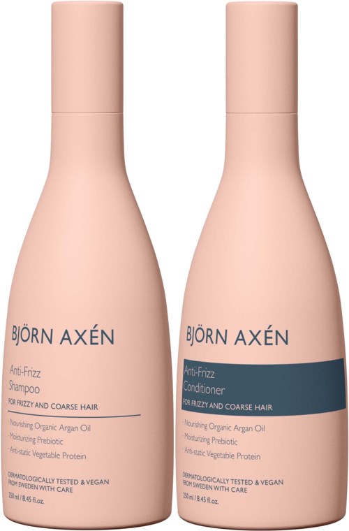Twee roze flessen van Björn Axén, shampoo en conditioner, voor kroesachtig, stug haar, met biologische olie en vegan ingrediënten.