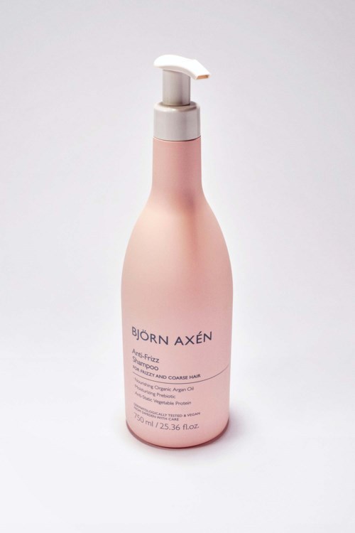 Een roze fles met een witte pomp, gelabeld 'Björn Axén' voor haarverzorgingsproducten.