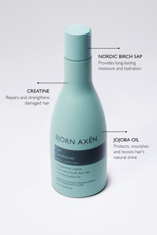 Fles met Bjorn Axen haarconditioner, bevat ingrediënten zoals Noorse berkensap, creatine en jojabeolie.