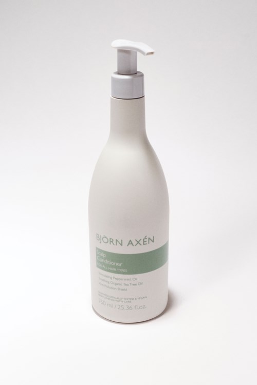 Een witte fles met pompdruk, gemarkeerd 'Biörn Axén' met tekst, waarschijnlijk een haar- of huidverzorgingsproduct.