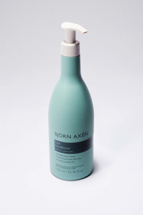 Een lichtblauwe fles met een witte pump, labeled 'Björn Axén' en meer tekst eronder.