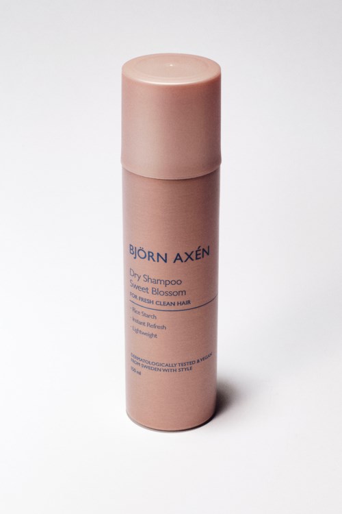 roze flesje droogshampoo met blauwe tekst, gelabeld als Björn Axén en zoete bloemengeur.