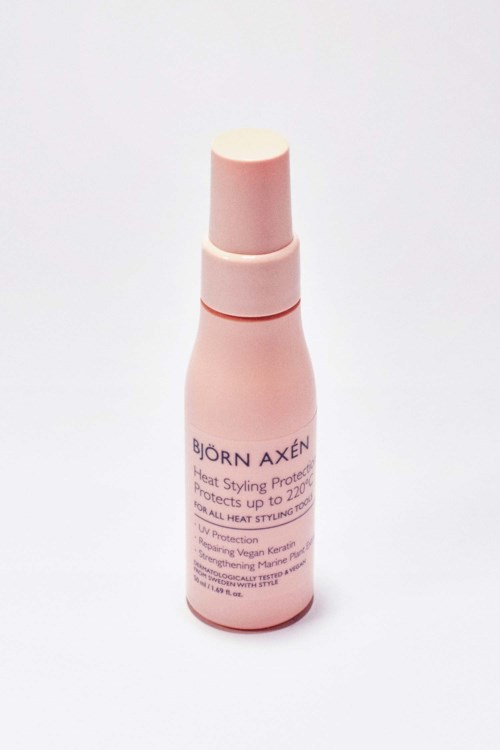 A pink bottle labeled Björn Axén, likely hair styling product, standing upright on a white background.