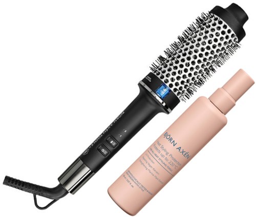 Eine runde Haarbürste mit schwarzem Griff und Borsten, und eine rosa Sprühflasche.