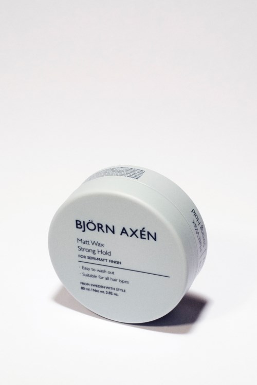 Eine runde Dose mit Björn Axén Haargel, weiße Beschriftung, auf weißer Oberfläche.