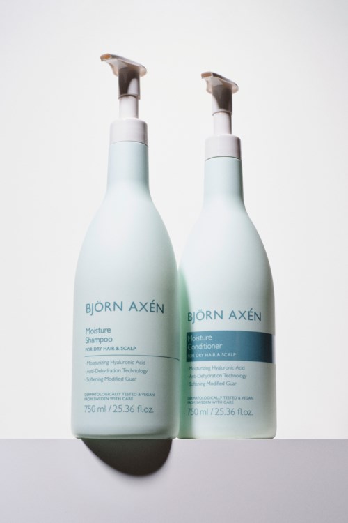 Twee witte flessen van Bjorn Axen haarverzorgingsproducten, shampoo en conditioner, met pompverdeler.