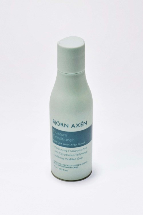 Een witte fles Björn Axén conditioner met een blauwe label, bedoeld voor haar, gezicht en hoofdhuidverzorging.