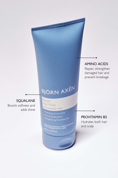 Blue tube of hair mask with labels for amino acids, squalane, and vitamin B5, written in black text.