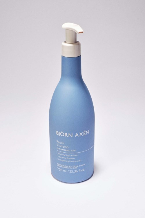 Een blauwe fles met een witte pomp, gemerkt 'BJÖRN AXÉN,' waarschijnlijk een huidverzorgings- of cosmeticaproduct.