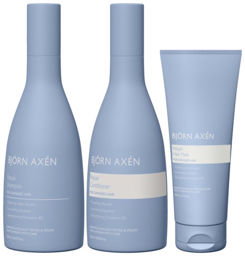 Drie lichtblauwe haarverzorgingsproducten: shampoo, conditioner en masker, met merknaam Björn Axén voor beschadigd haar.