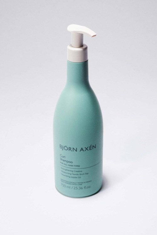 Een blauwgroene fles met witte pomp, gemerkt Björn Axén, bevat haarverzorgingsproduct.