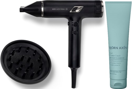 Ein schwarzer Haartrockner, ein Diffusor, und eine blaue Tube mit Creme mit Text. Der Haartrockner hat silberne Akzente.