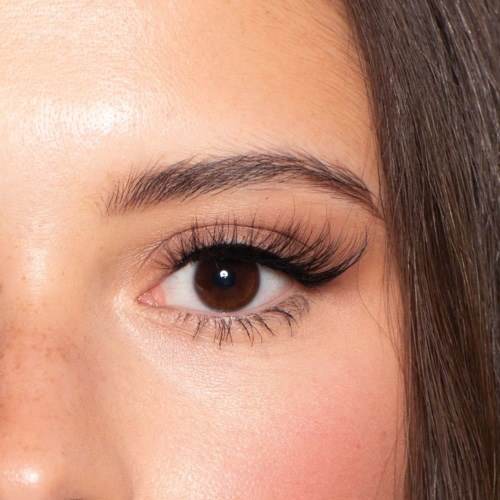 Een oog van een vrouw met lange wimpers en bruin iris, toont heldere huid en wenkbrauwhaar. Het oog kijkt recht voor zich uit.