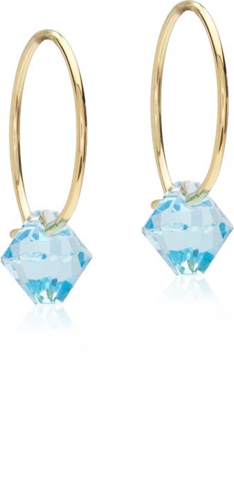 Gold hoop earrings with large blue gemstone pendants hang freely.